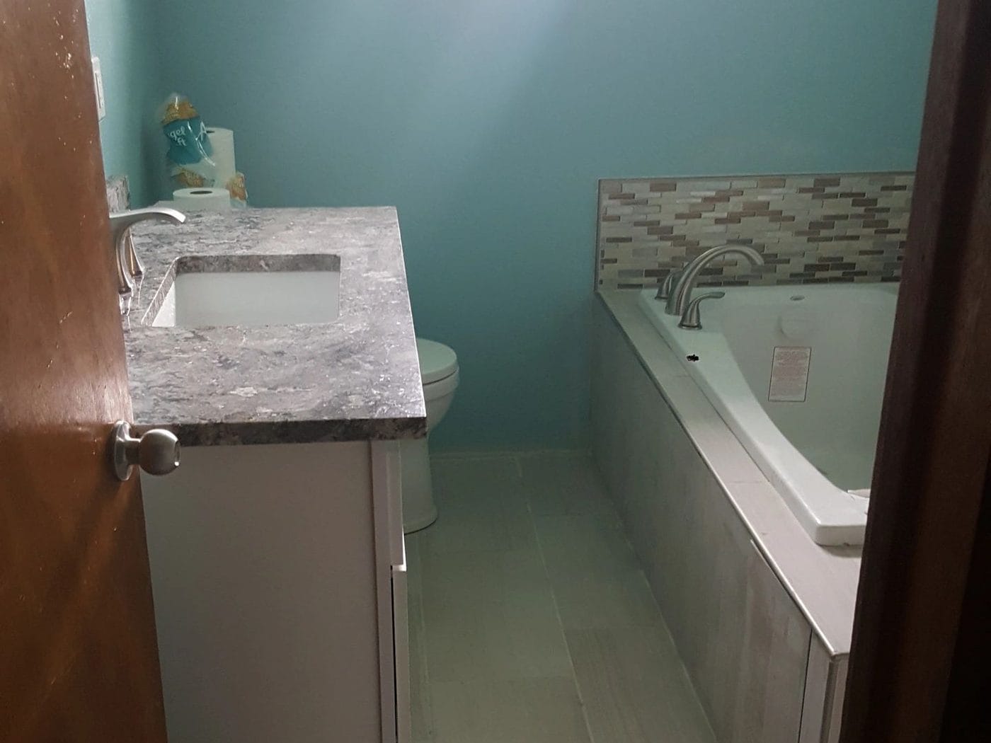 A stone vanity top alongside a drop-in tub