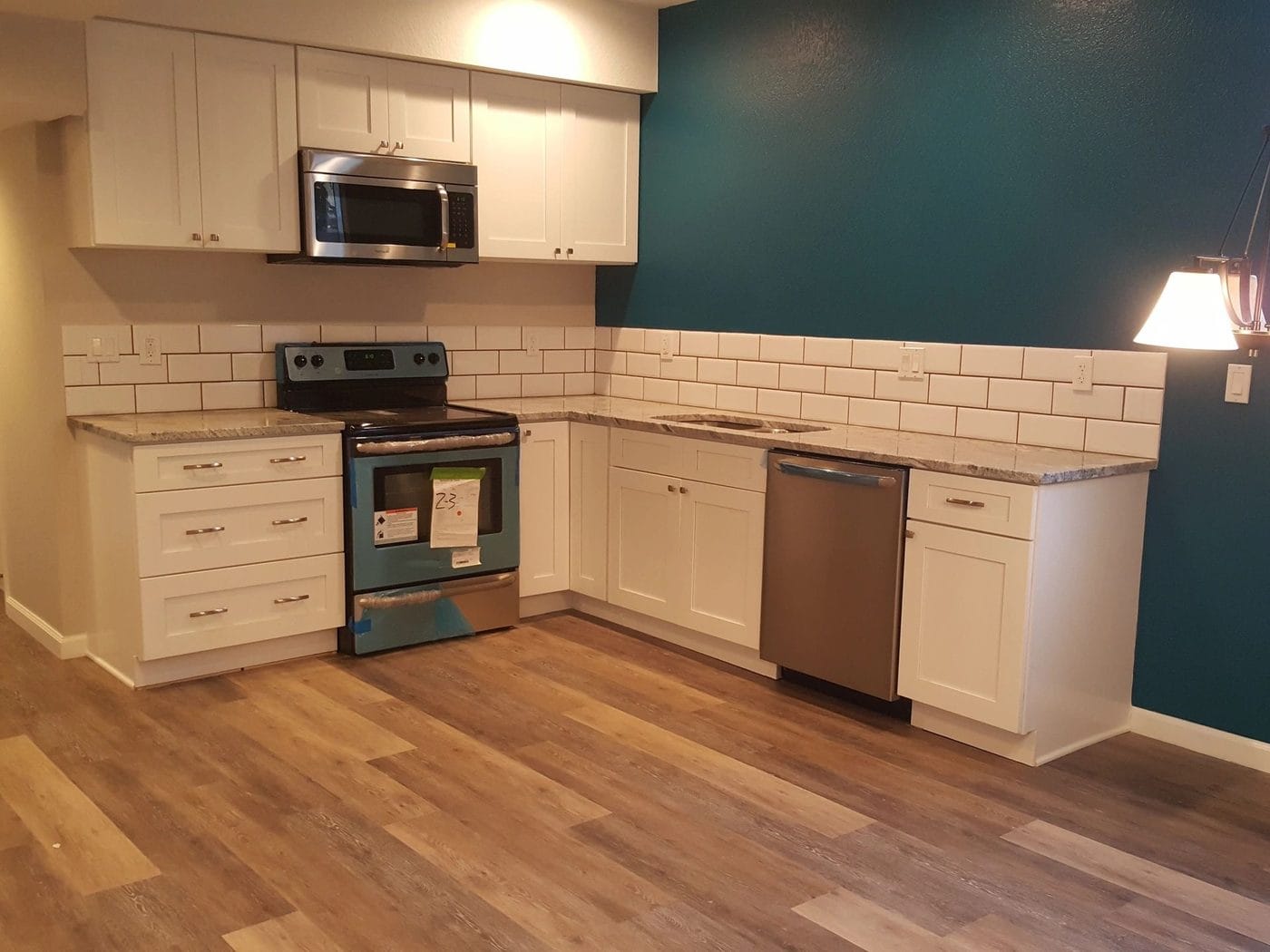A kitchen with white cabinetry and a subway tile backsplash
