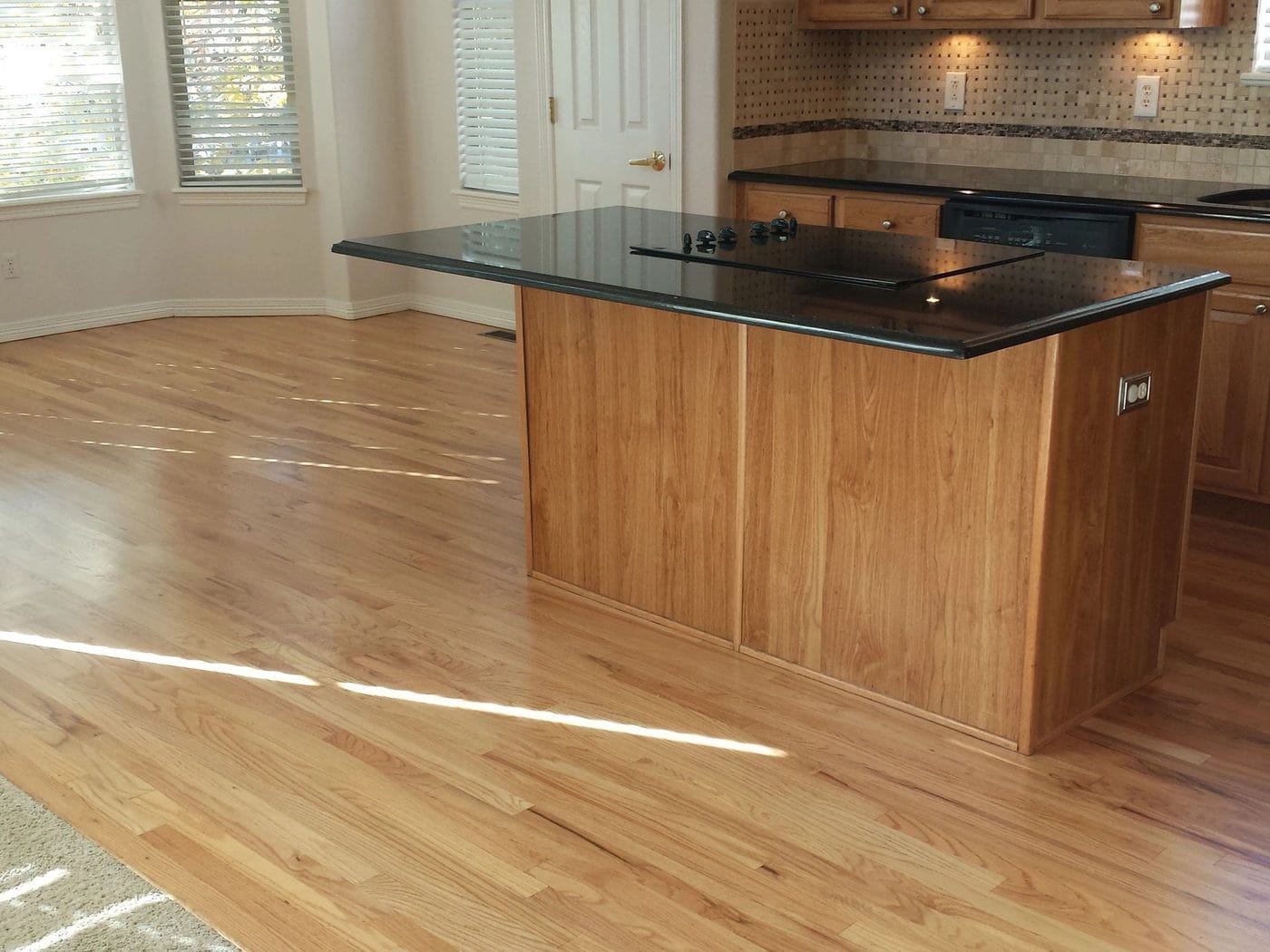 An open kitchen with an island and a hardwood floor