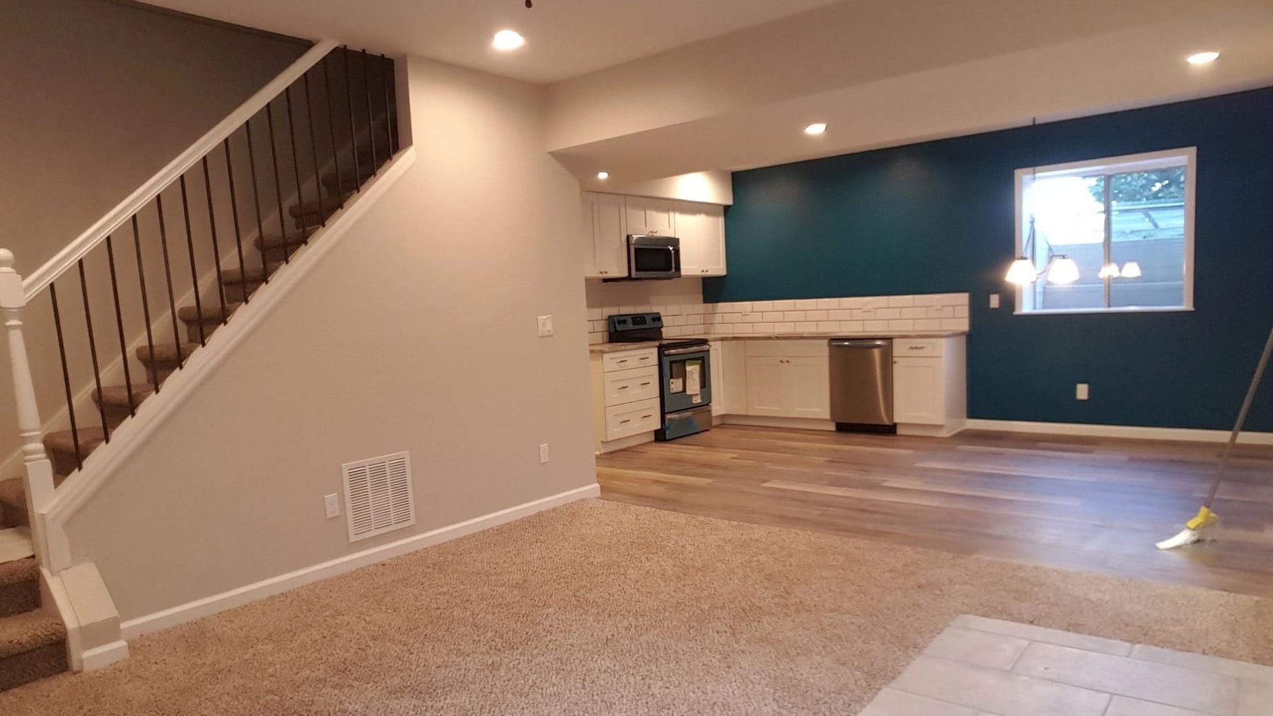 A finished lower level with a new stair, a wet bar and a painted accent wall