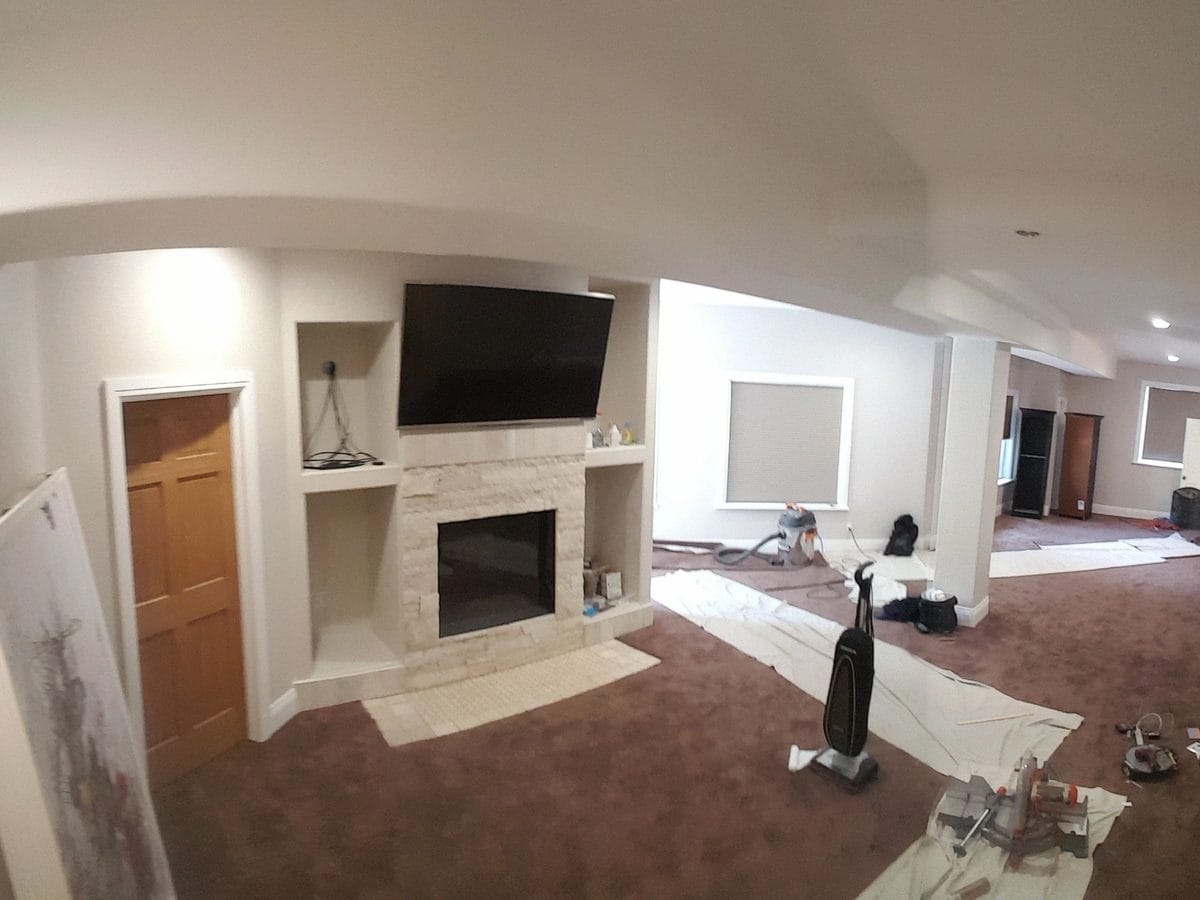 A basement part way through, with a fireplace surround and built-ins framed