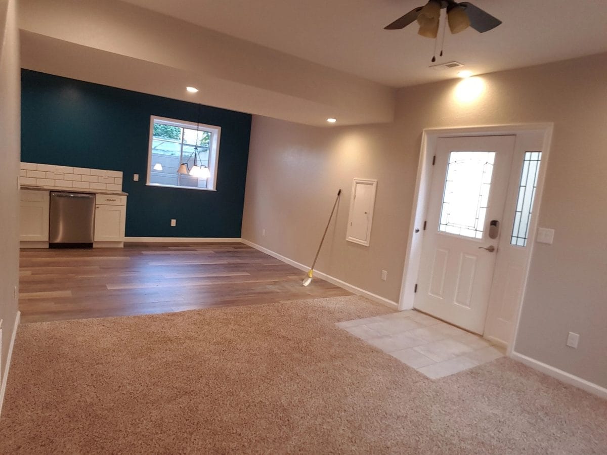 A finished basement with new flooring and a painted accent wall